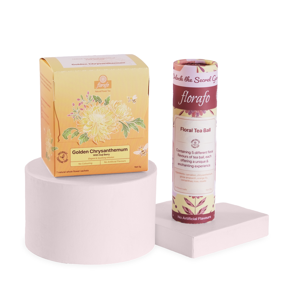 florafo bundle of a box of Golden Chysanthemum whole flower infusions next to a paper tube of Floral Tea Ball flower balls. The box is sitting on a pastel pink cylindrical platform and the tube is standing on a lower square pastel pink platform.